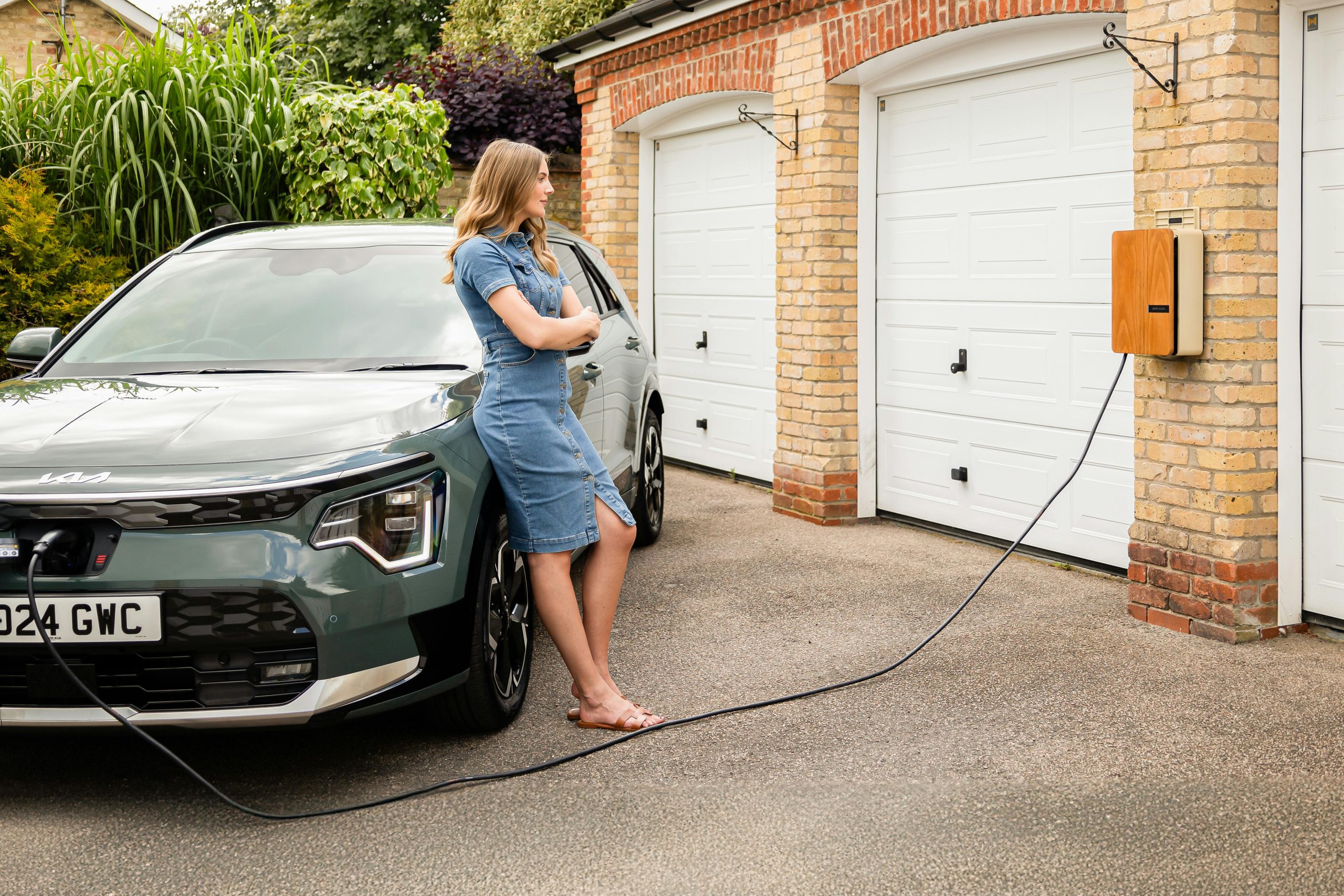 Women leaning on an electric car